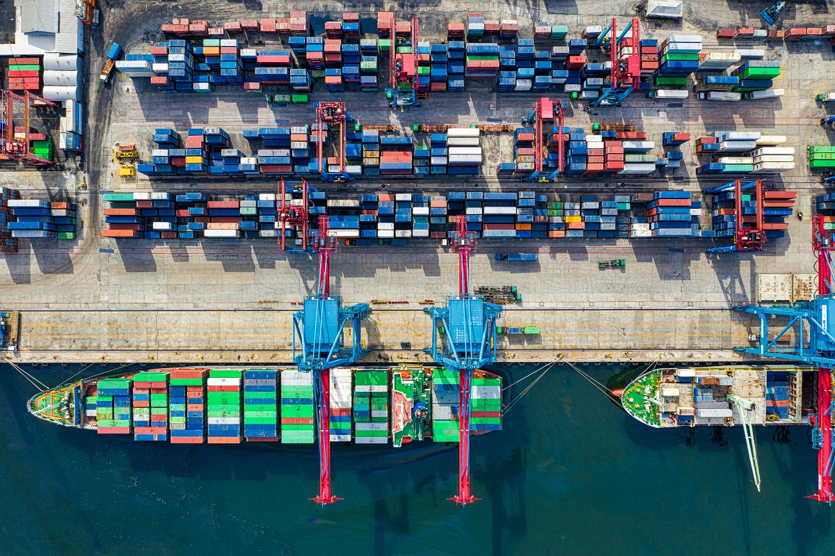 aerial view of a cargo ship surrounded by colorful shipping containers